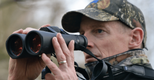 A man spotting a game species using his hunting rangefinder