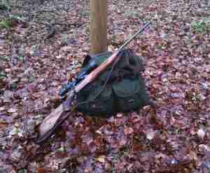 A green hunting backpack and a rifle in the fall